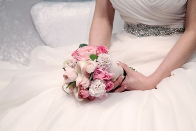a woman in a wedding dress holding a bouquet of flowers