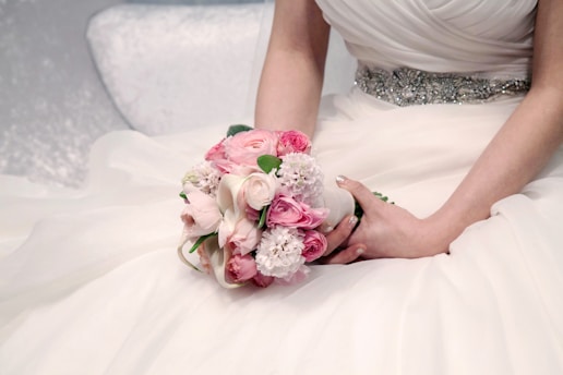 a woman in a wedding dress holding a bouquet of flowers