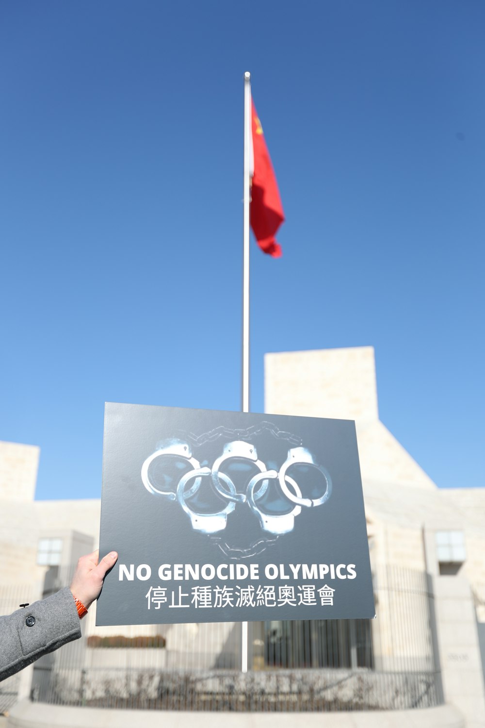 a person holding up a sign in front of a building