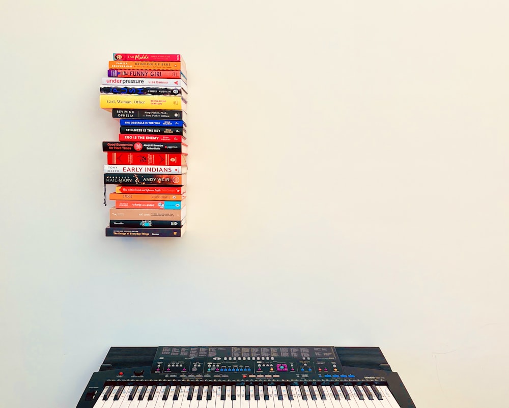a keyboard with a stack of books on top of it