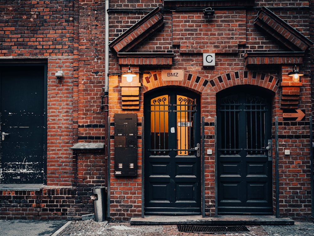 a red brick building with two black doors