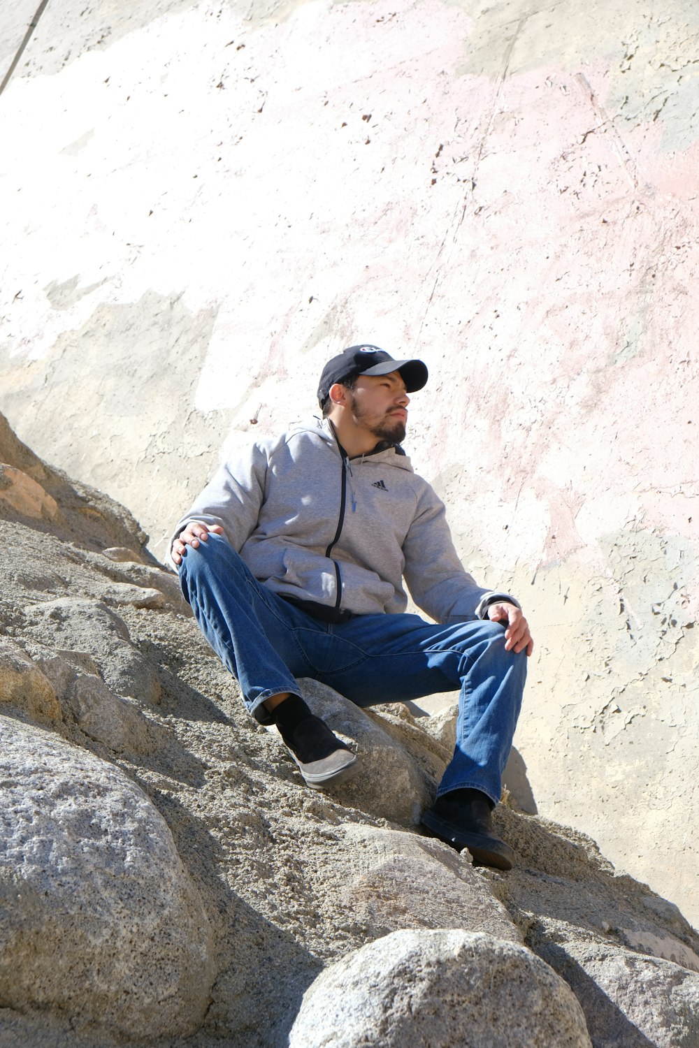 a man sitting on top of a large rock