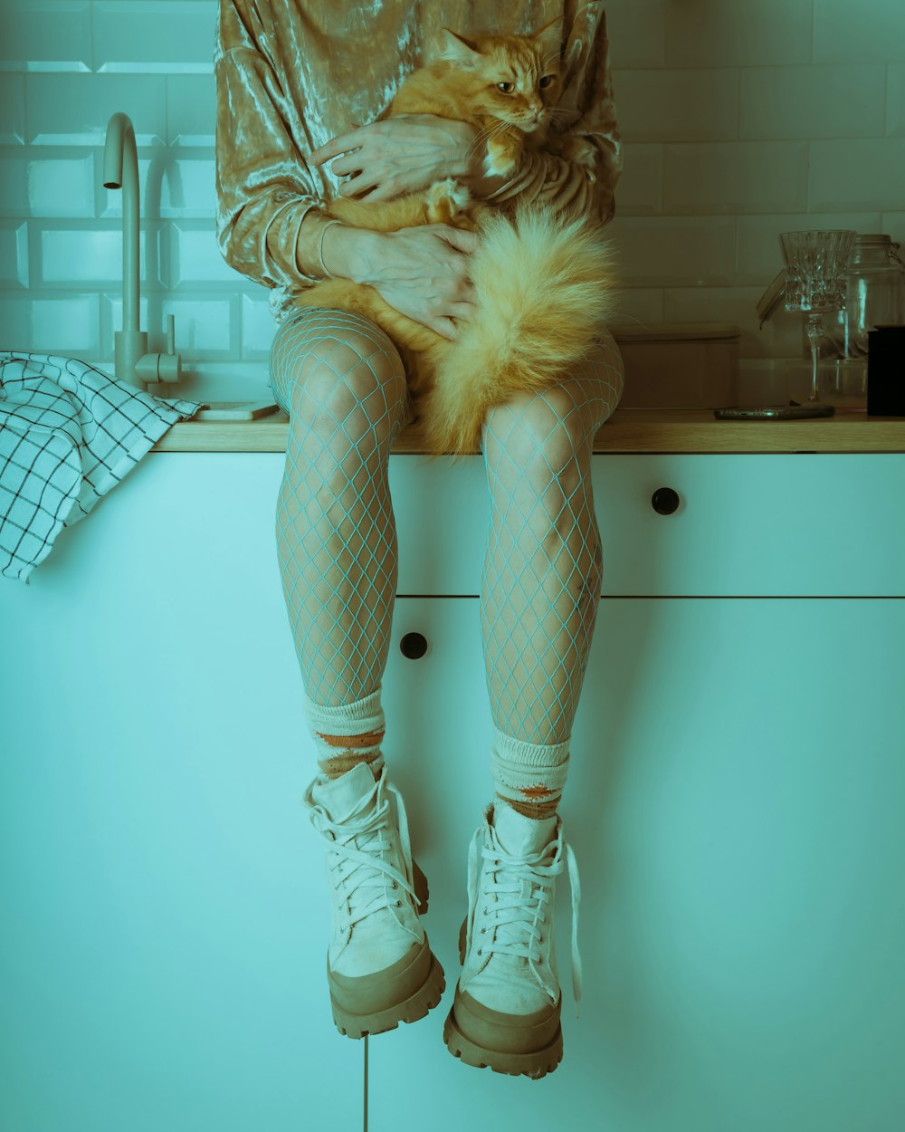 a woman sitting on top of a counter holding a dog