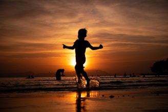 a child running on the beach at sunset