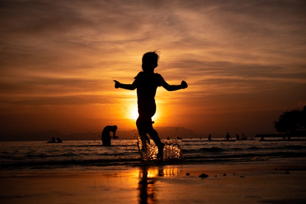a child running on the beach at sunset