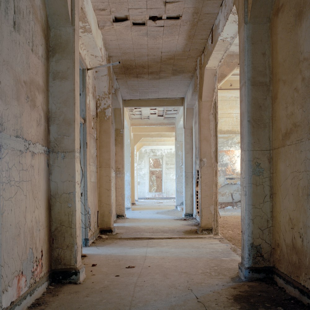 a long hallway in an abandoned building with graffiti on the walls