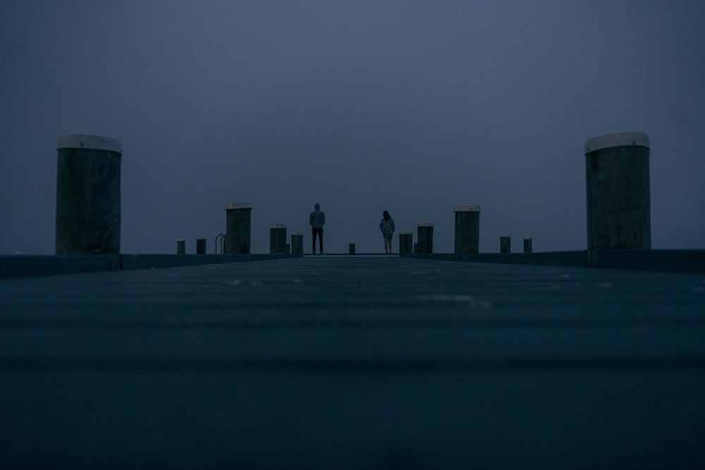 a person standing on a pier at night