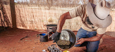 Artisan carefully mixing natural ingredients for rapé in a rustic setting