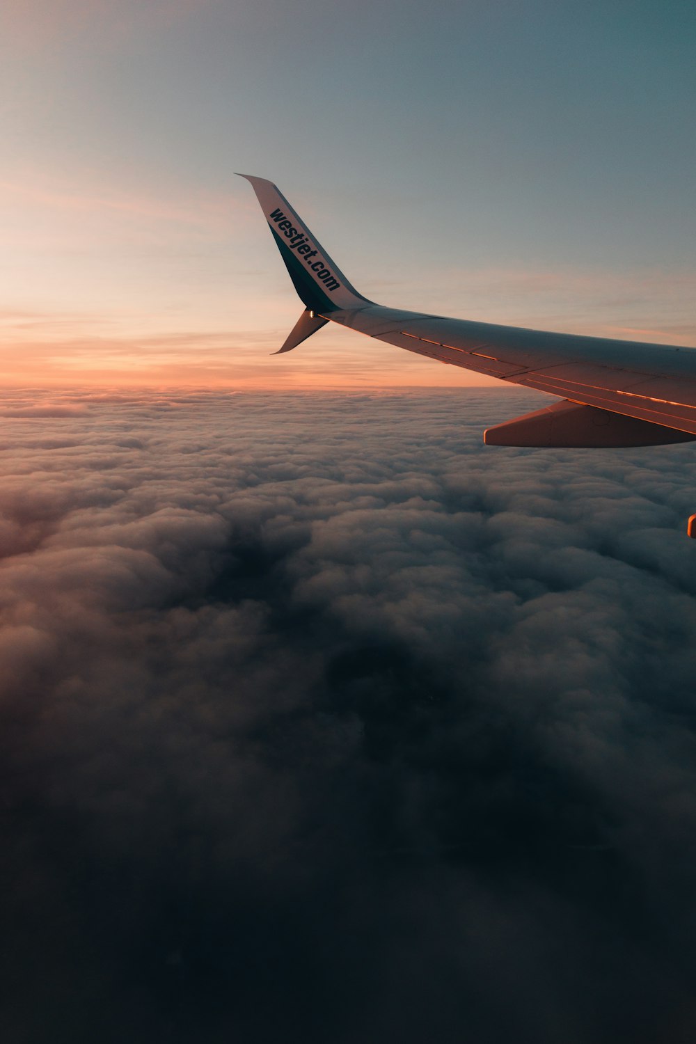 a view of the wing of an airplane above the clouds