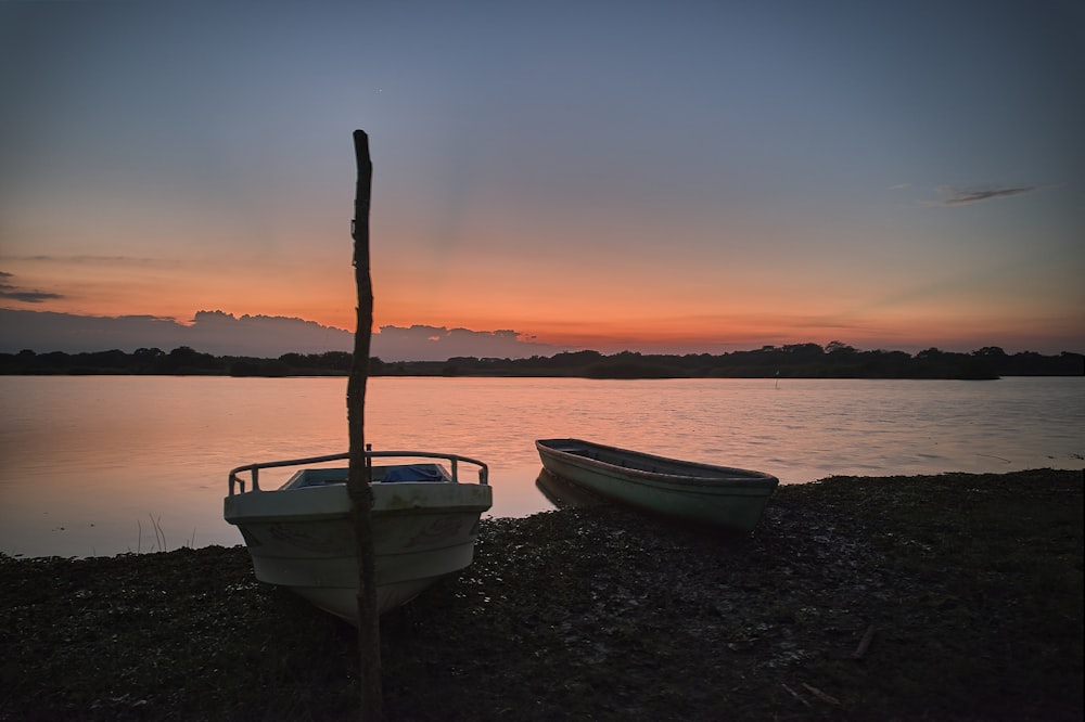 a couple of boats sitting on top of a lake