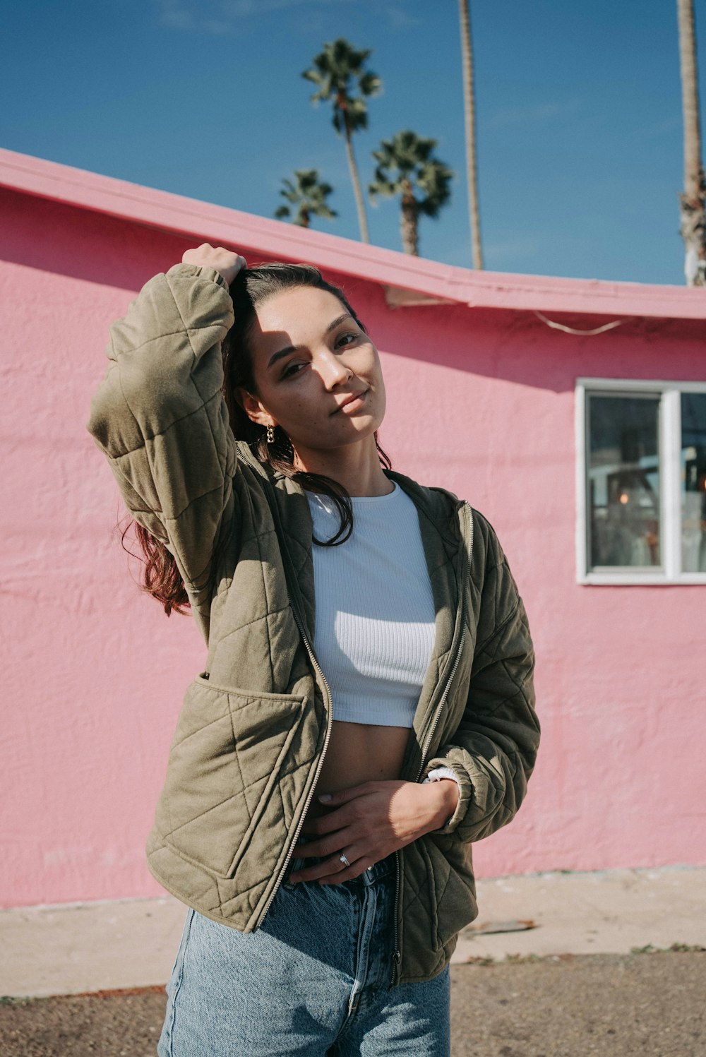 a woman standing in front of a pink building