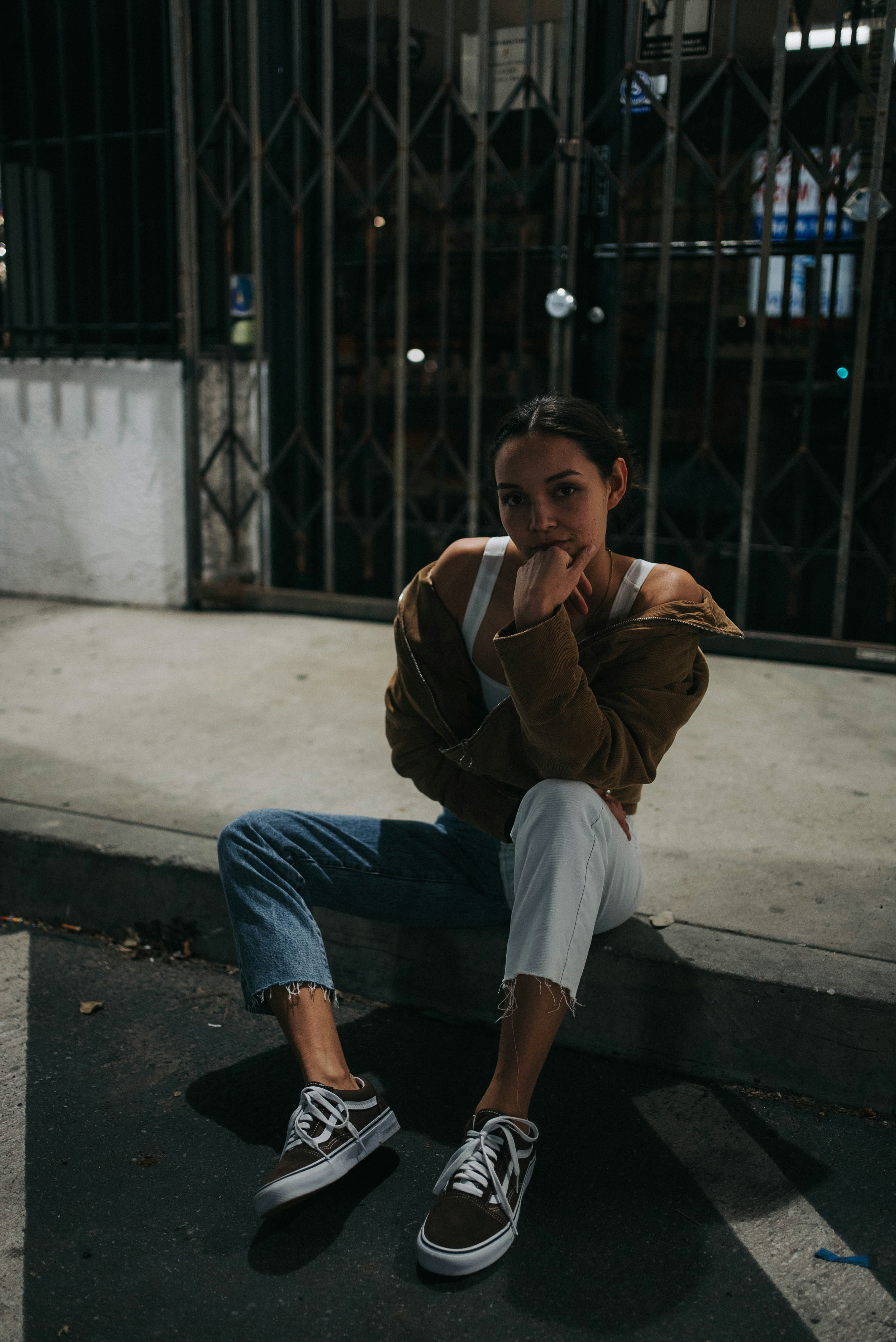 a woman sitting on the ground with her hand on her face