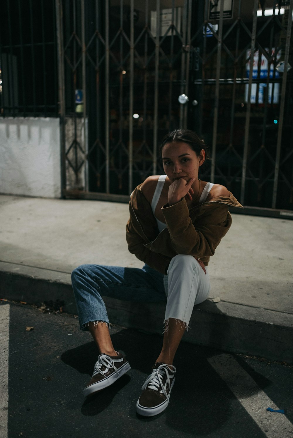 a woman sitting on the ground with her hand on her face