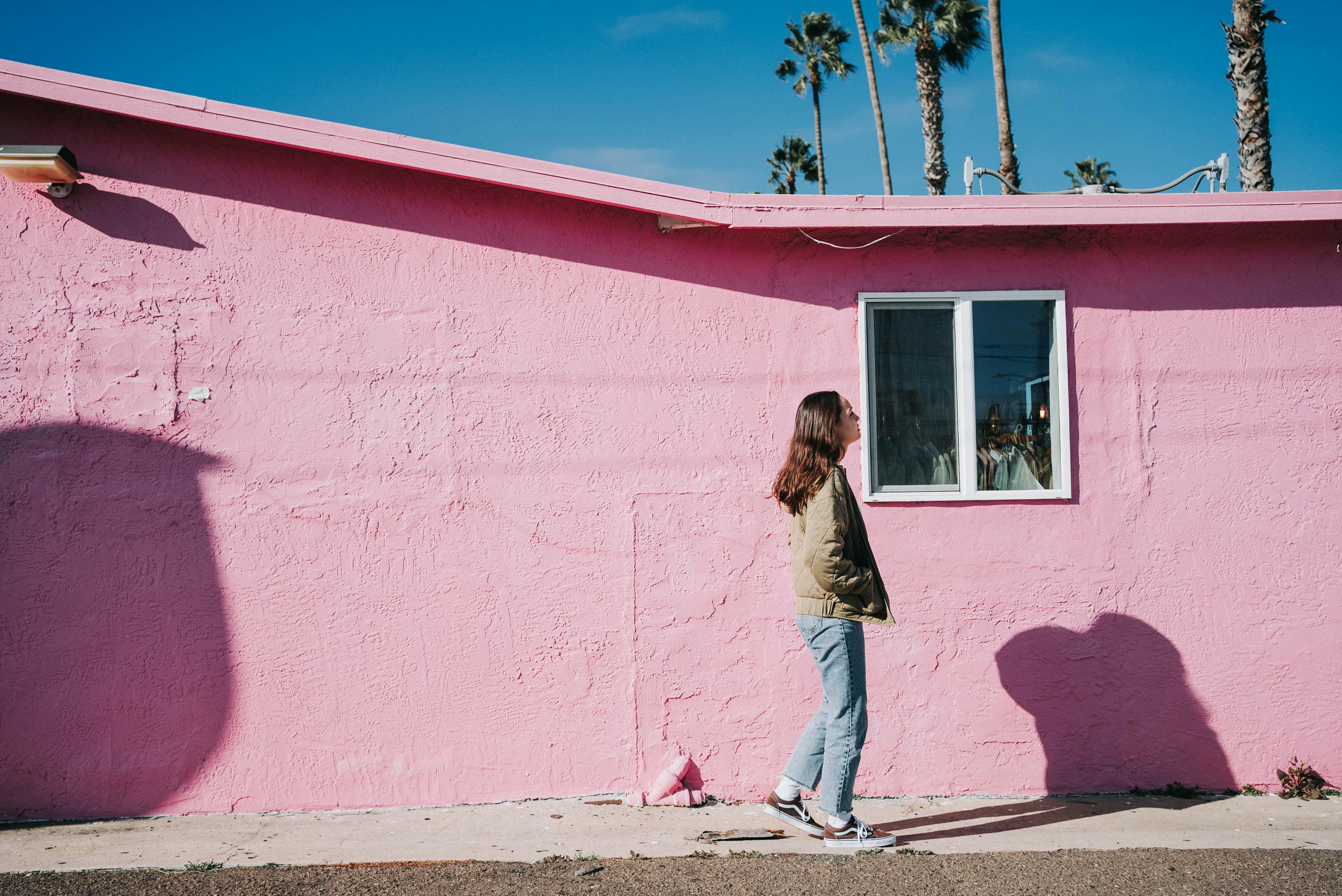 a woman standing in front of a pink building