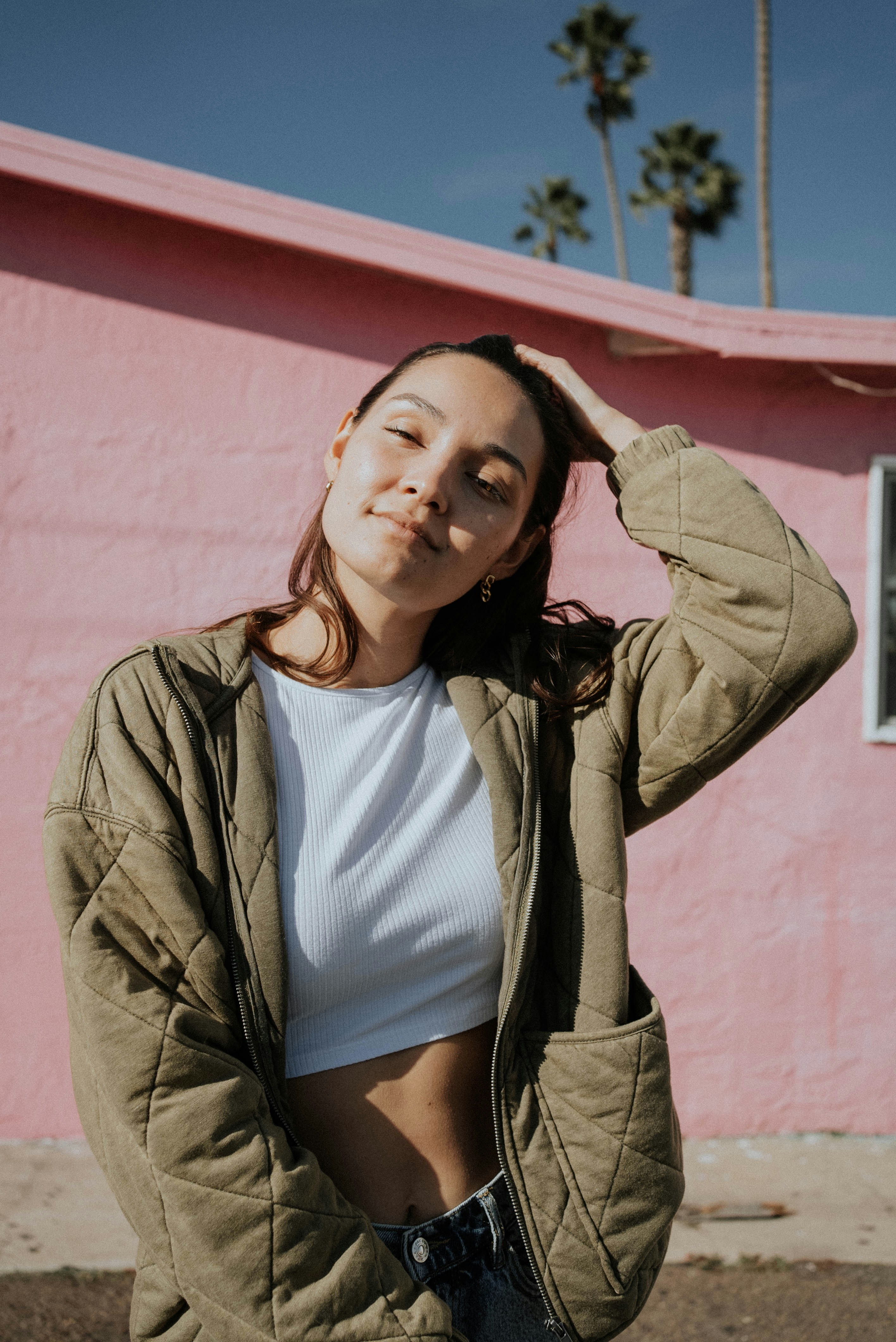 a woman standing in front of a pink building