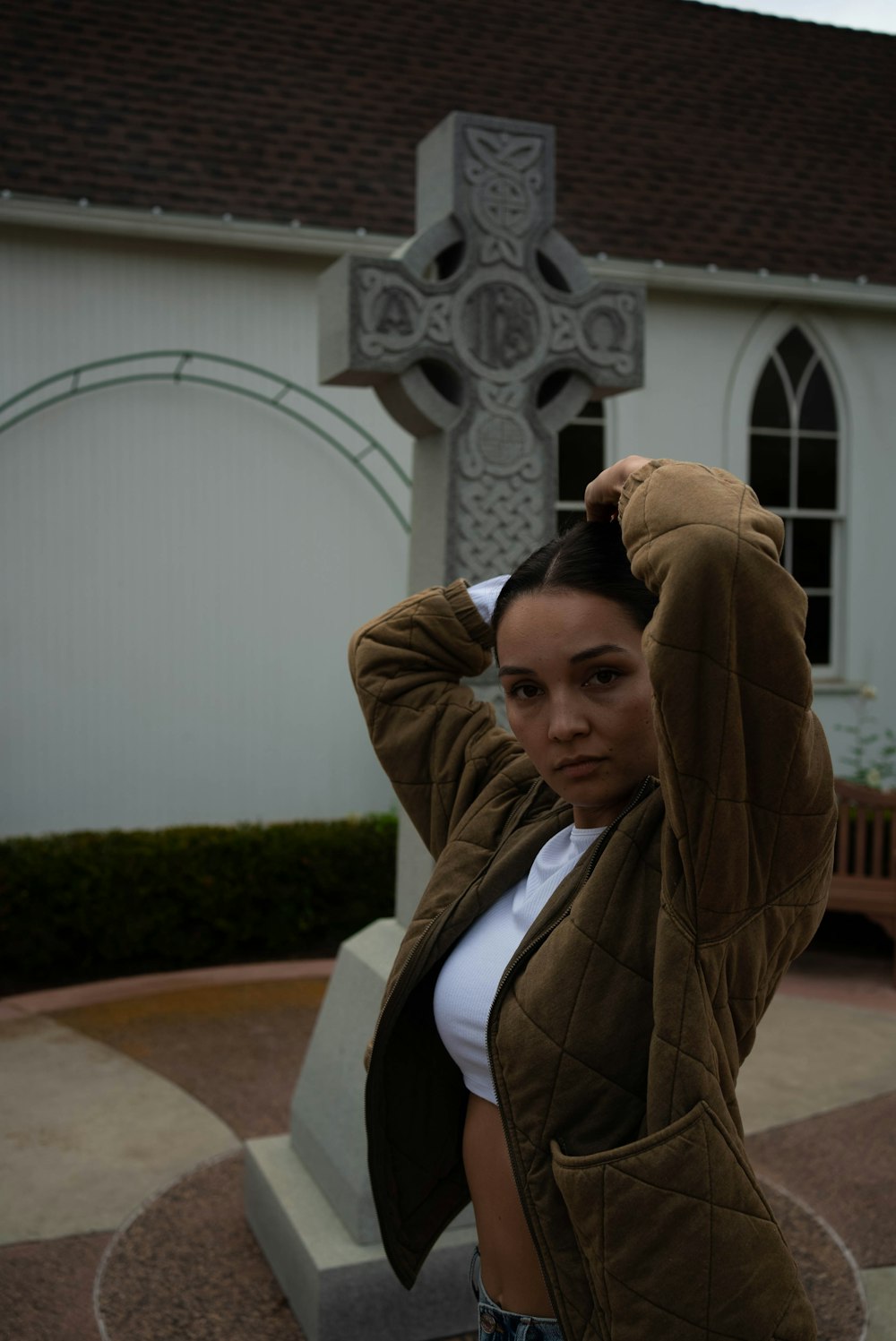 a woman standing in front of a cross