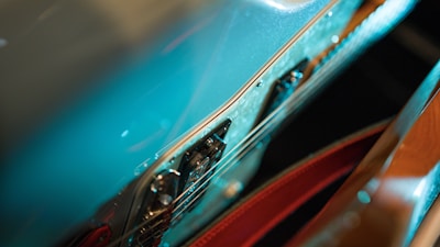 Close-up of a guitar with psychedelic patterns reflected on its surface.
