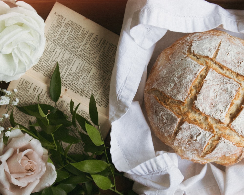 a loaf of bread sitting on top of a table next to flowers