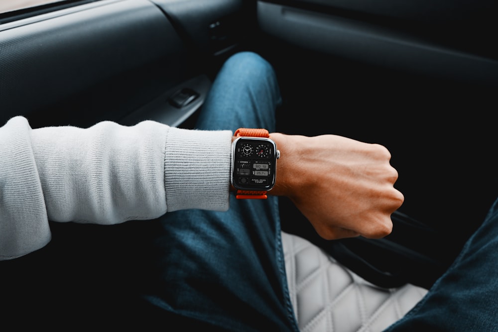 a person sitting in a car with a watch on their wrist