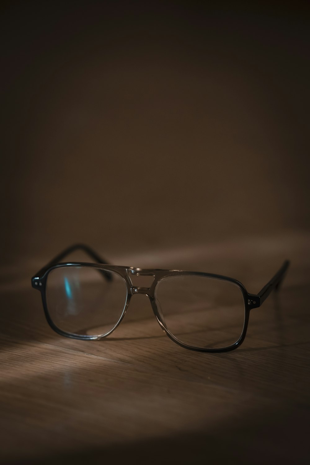 a pair of glasses sitting on top of a wooden table