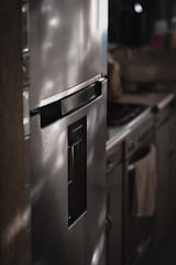 a metallic refrigerator freezer sitting inside of a kitchen