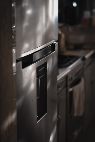 a metallic refrigerator freezer sitting inside of a kitchen