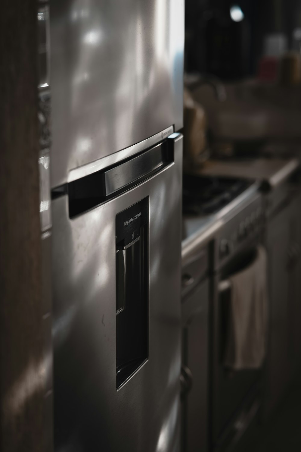 a metallic refrigerator freezer sitting inside of a kitchen