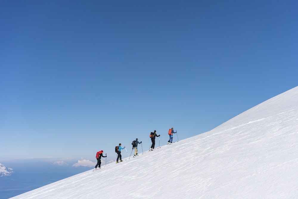 a group of people riding skis on top of a snow covered slope