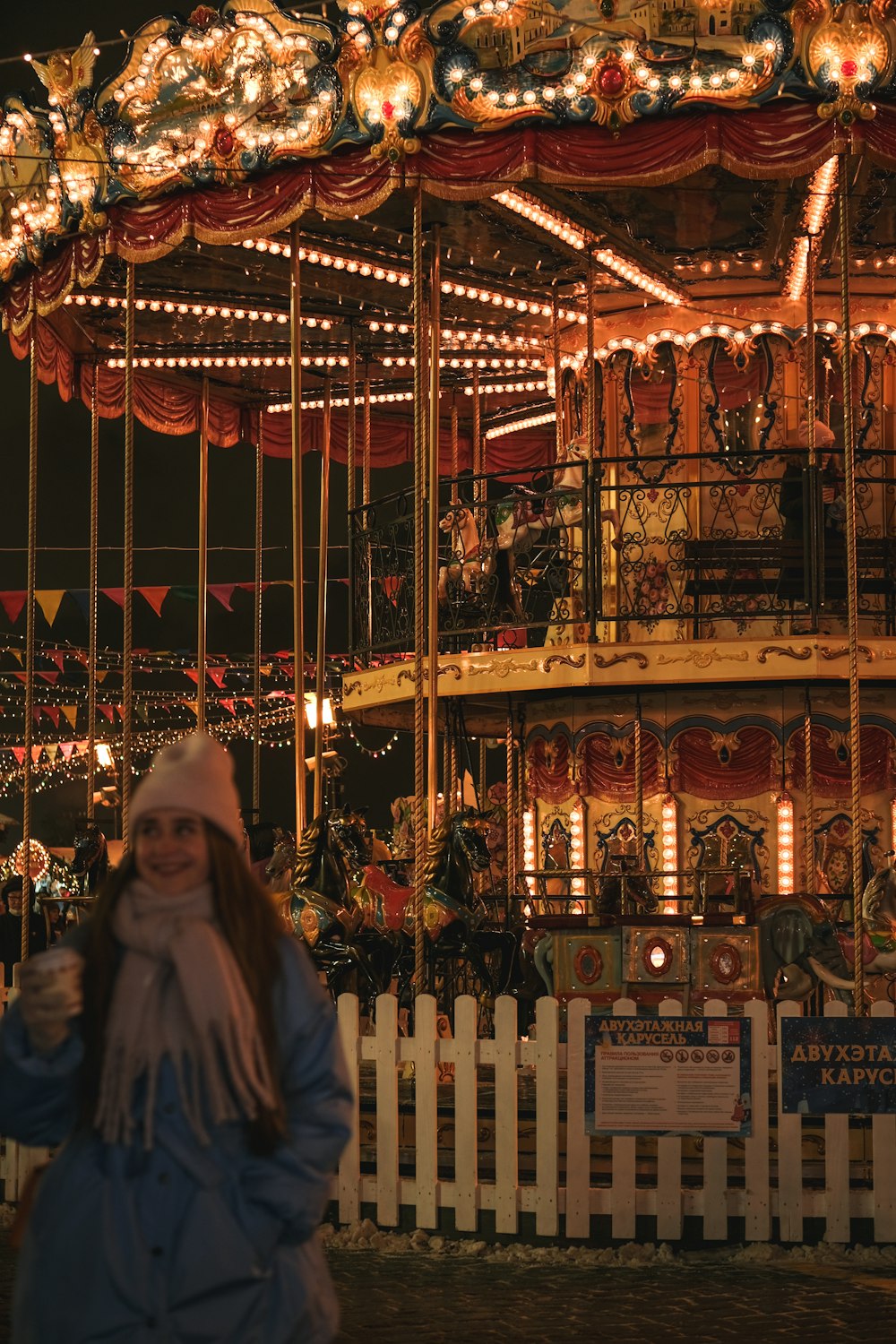 a woman standing in front of a merry go round