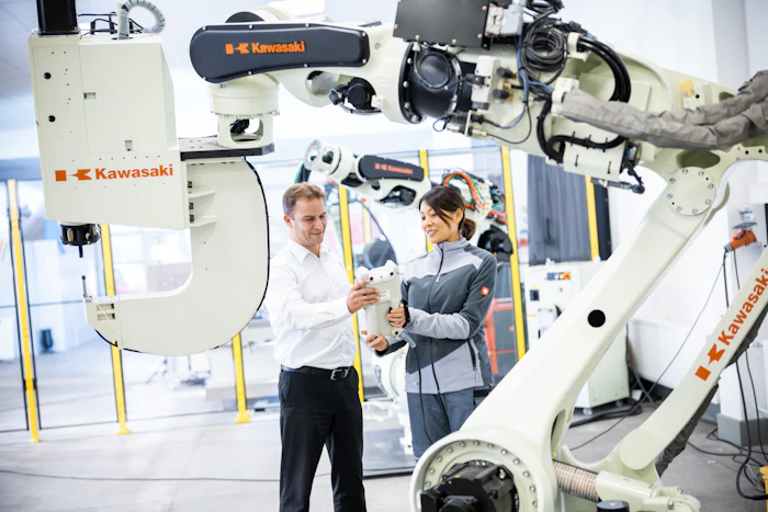 Engineers collaborating with an industrial robot on the factory floor