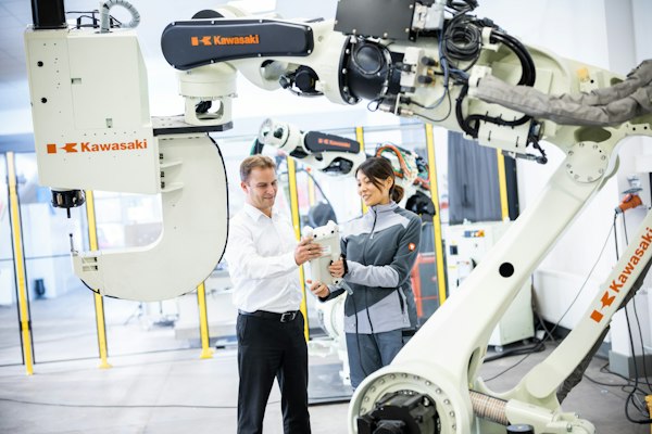 Personal de planta frente a un robot, parte del posicionamiento web para proveedores de robótica industrial