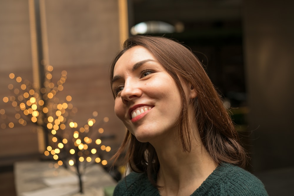 Una mujer sonriendo frente a un árbol de Navidad