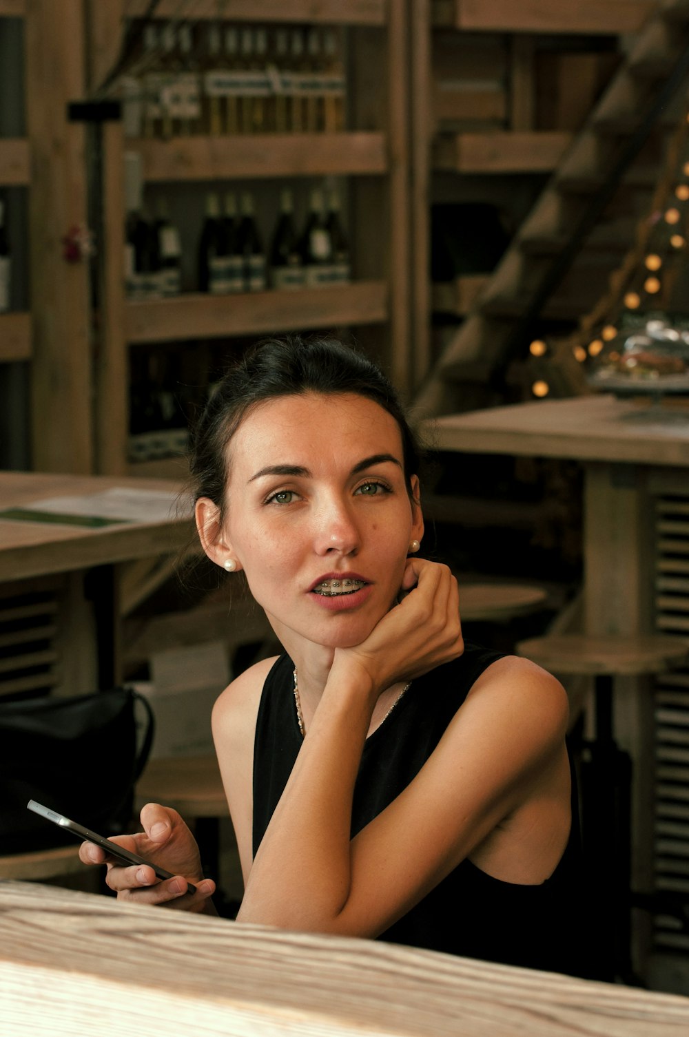 a woman sitting at a table with a cigarette in her hand