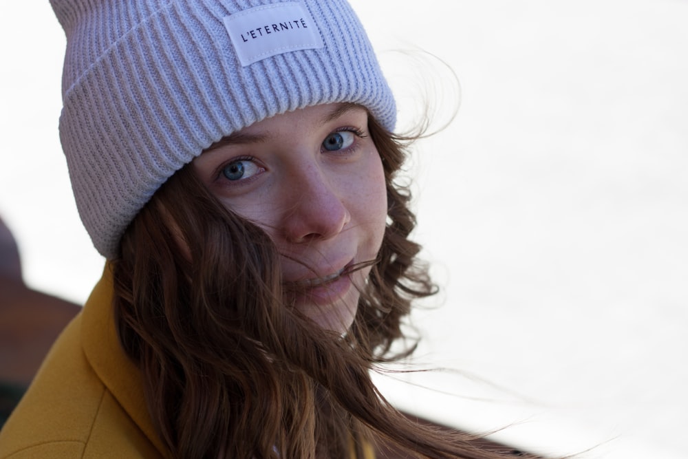 a woman with long hair wearing a beanie