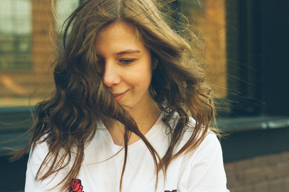 a girl with long hair is looking at her cell phone