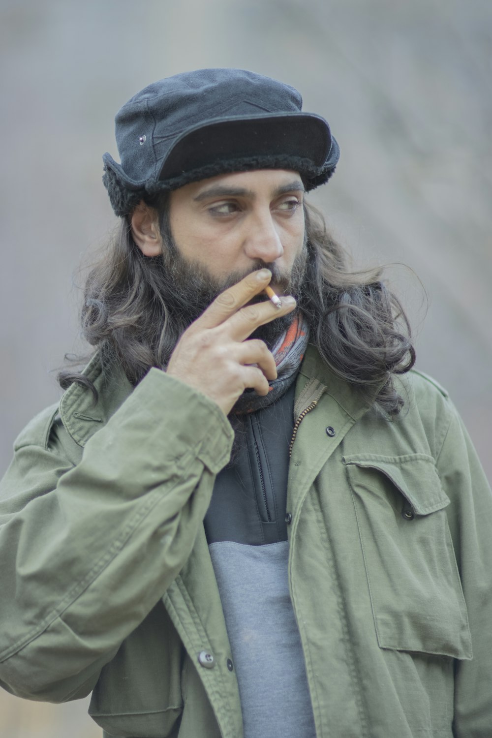 a man with long hair is smoking a cigarette