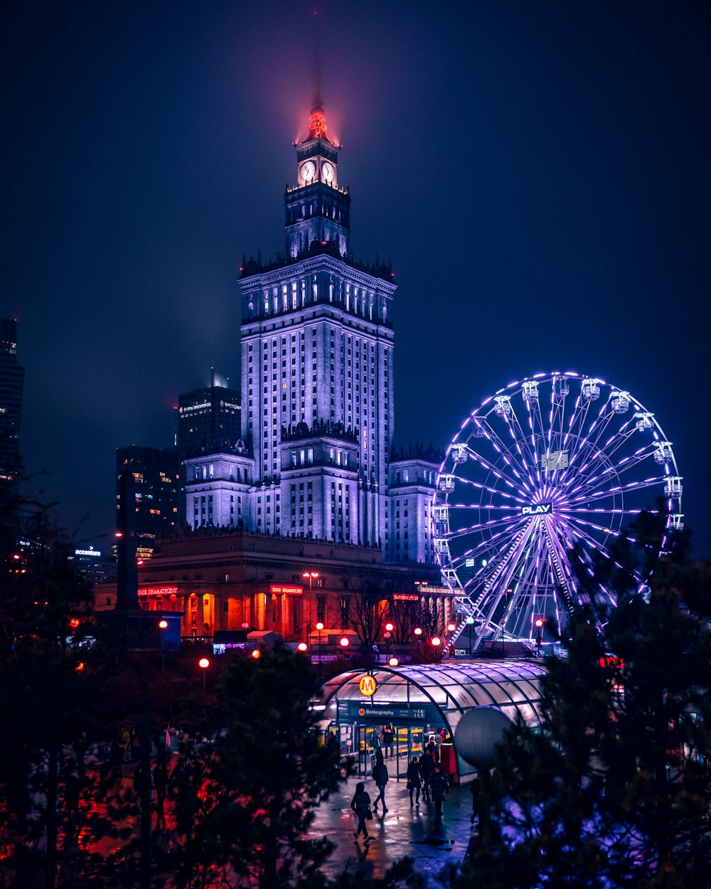 a large building with a ferris wheel in front of it