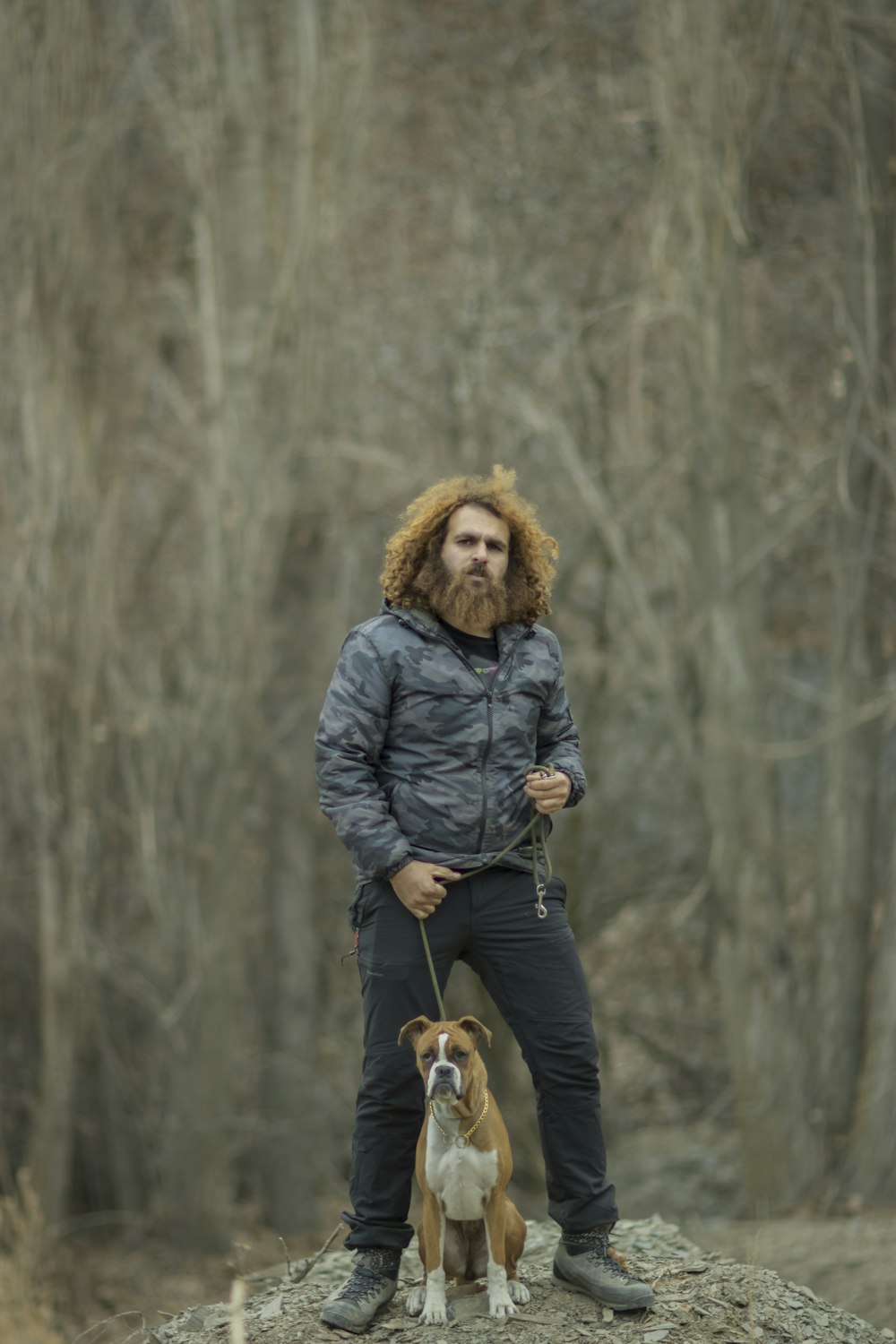 Un uomo con la barba in piedi accanto a un cane