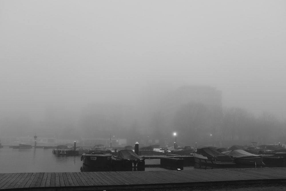 a black and white photo of a foggy harbor