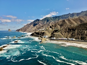 a scenic view of the ocean with mountains in the background