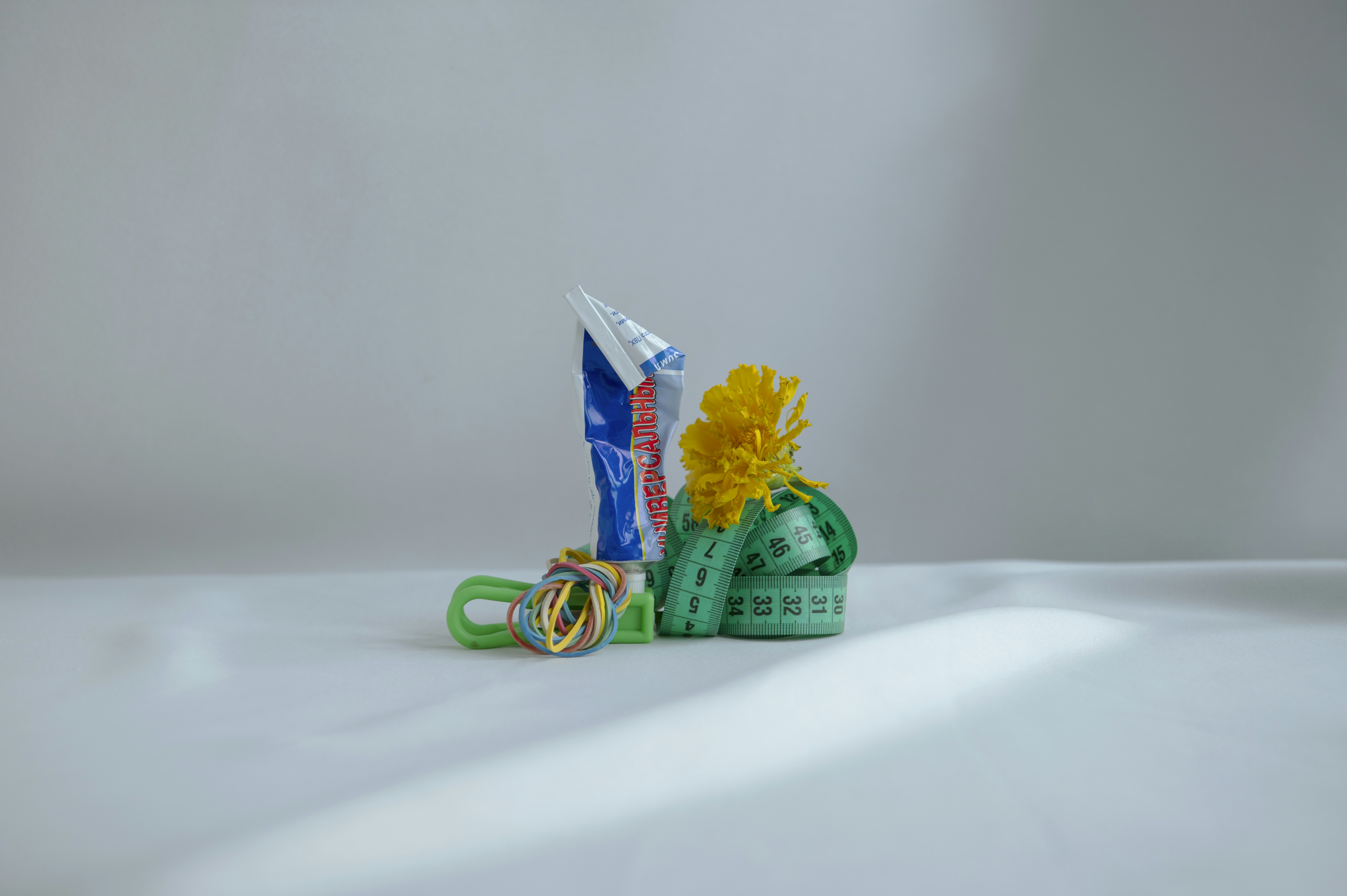 a yellow flower sitting on top of a pair of scissors
