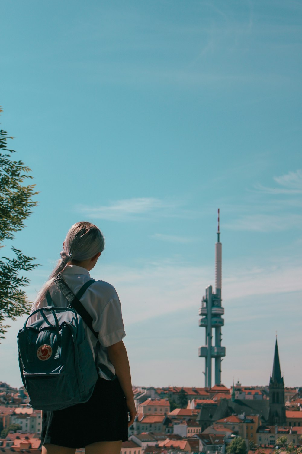 a woman with a backpack looking at a city