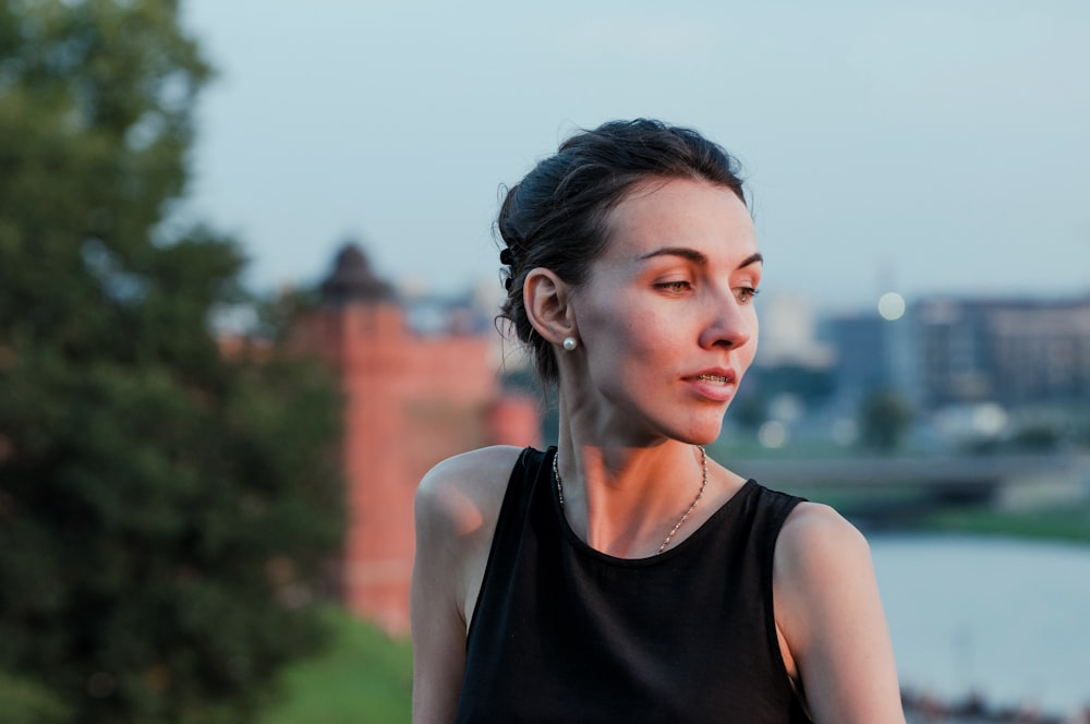 a woman in a black top looks off into the distance