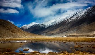 a mountain range with a lake in the foreground