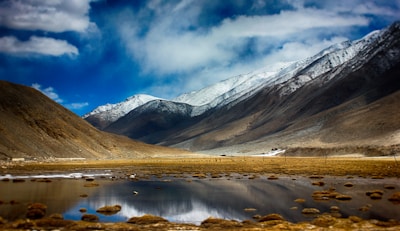 a mountain range with a lake in the foreground