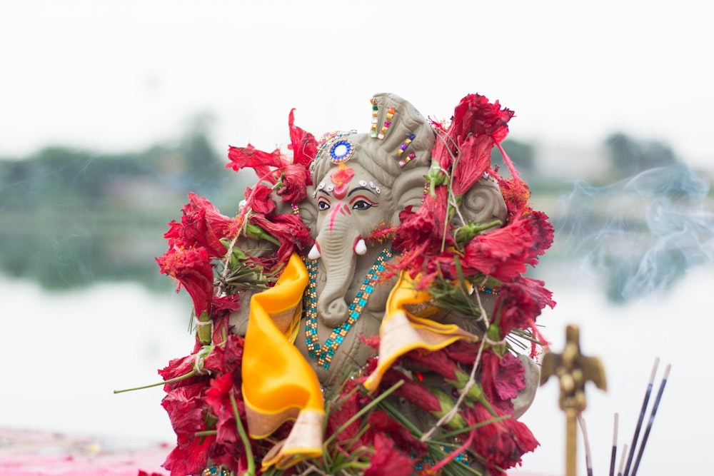 a statue of an elephant with flowers in its trunk