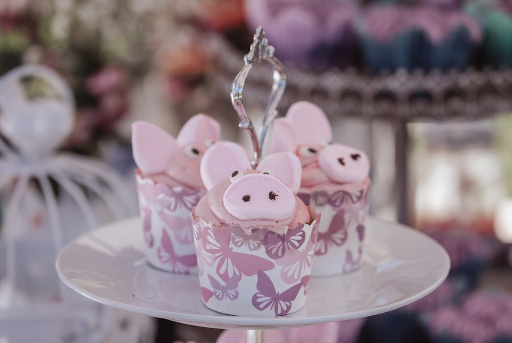 cupcakes with pink decorations on a cake stand