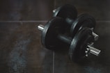 Close-up of premium fitness gear including weights and resistance bands on a minimalist black surface