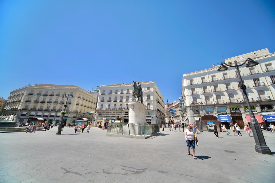 a woman is standing in the middle of a square, Puerta Del Sol