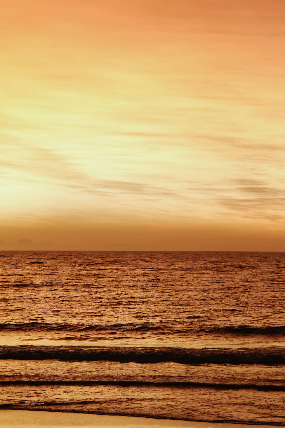 a person walking on the beach with a surfboard